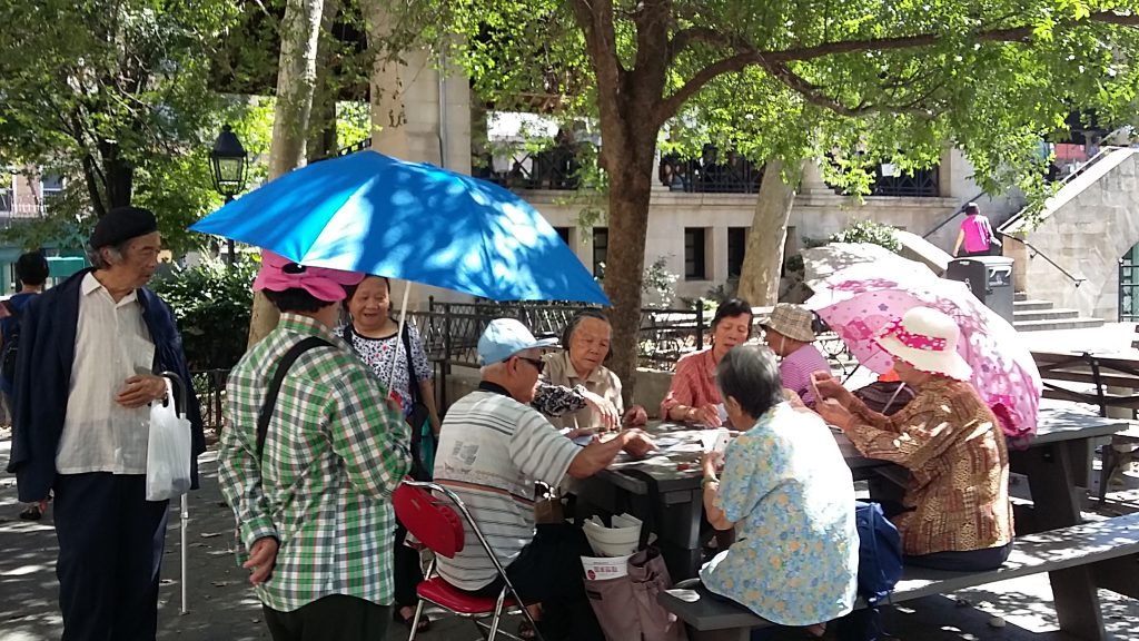 Parque lleno de chinos en Chinatown jugando al Mahjong, al domino y a las cartas